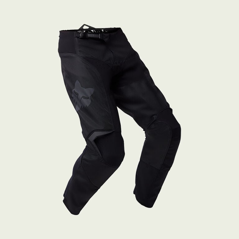 black moto pants on green background