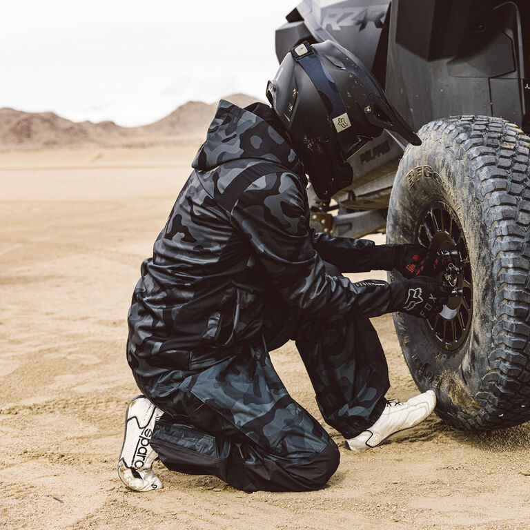 Man changing the tire on this side by side