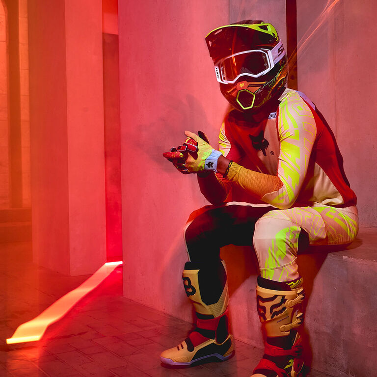 motocross rider sitting on stair in bright mx gear