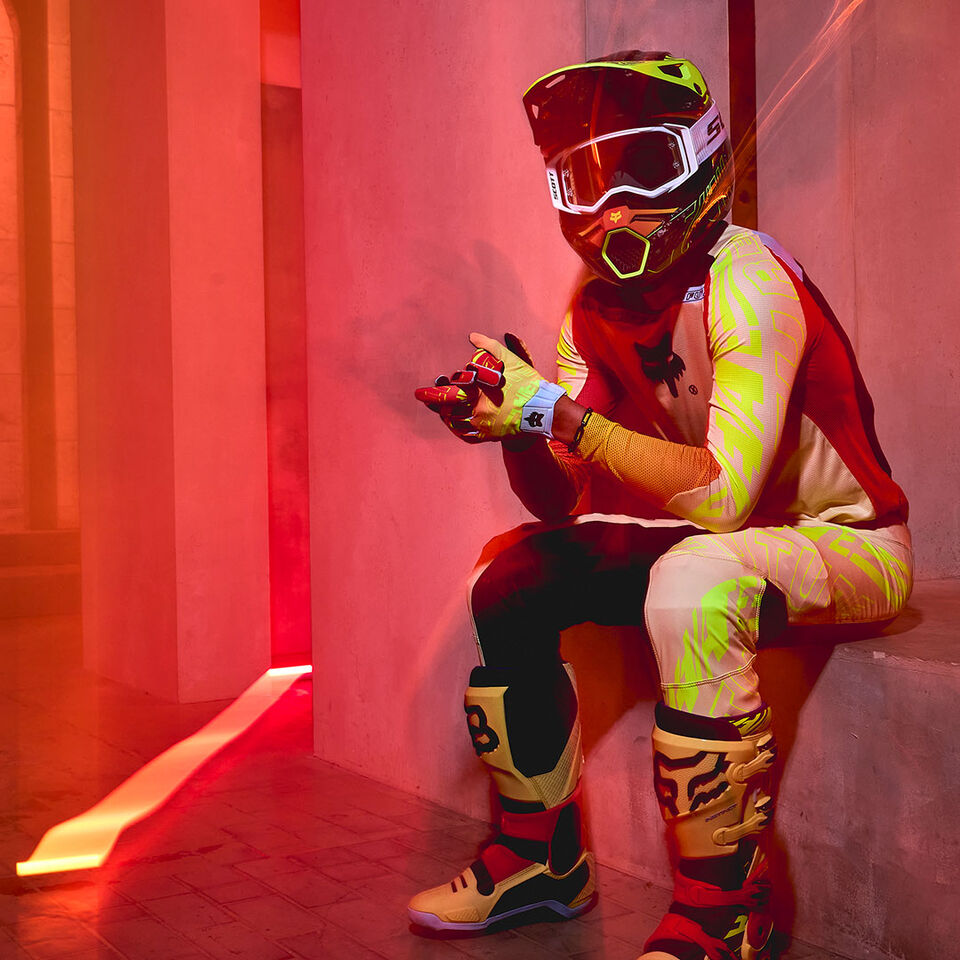 motocross rider sitting on stair in bright mx gear