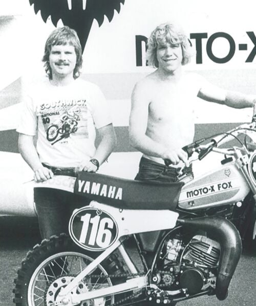 A black and white photo of two men with a dirt bike