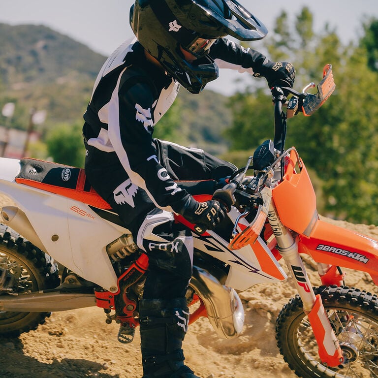 kid riding a dirt bike in black and white 180 gear