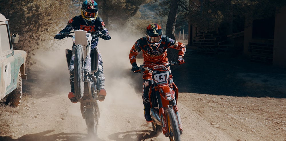 Two dirt bikers riding side by side.